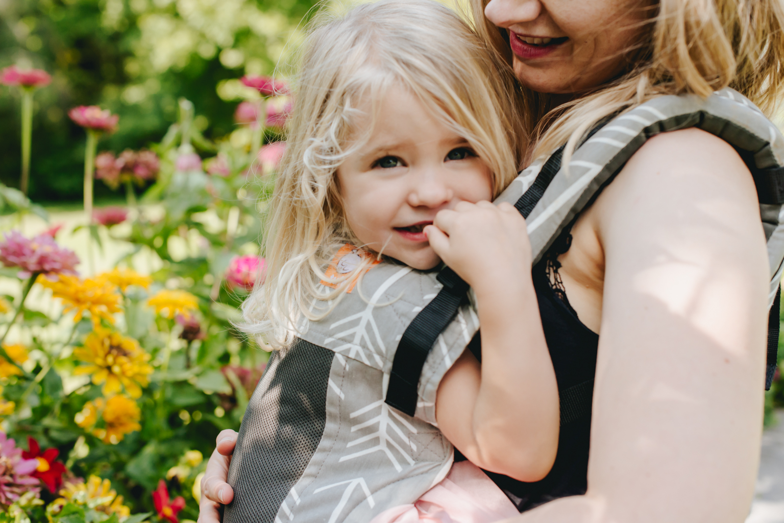 mom carrying toddler in a backpack style carrier