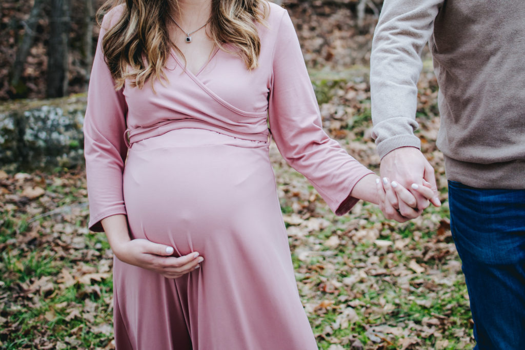 pregnancy loss. maternity photo of husband and wife holding hands