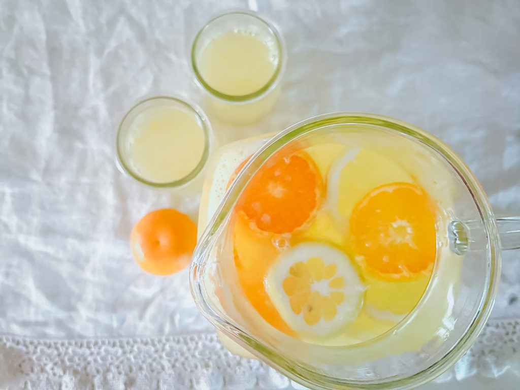 birds eye view of a pitcher of lemonade with lots of floating fruit.